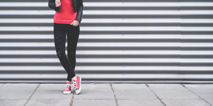 Young Woman Standing in Front of Metallic Wall